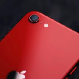 Telefon iPhone SE 2021, pe roșu, pe un fundal negru. Evenimentul Apple de pe 8 martie 2022 ar putea dezvălui un nou telefon iPhone SE