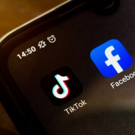 Aplicațiile TikTok și Facebook pe ecranul negru al unui telefon, cu fundal de lemn. Facebook ar fi plătit o firmă de consultanță să convingă utilizatorii să stea departe de TikTok