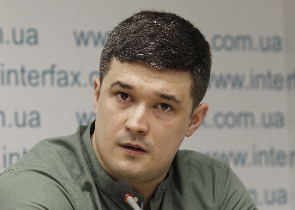 Mykhailo Fedorov, în cadrul unei conferințe de presă din anul 2019, cu fundal alb și o cămașă gri