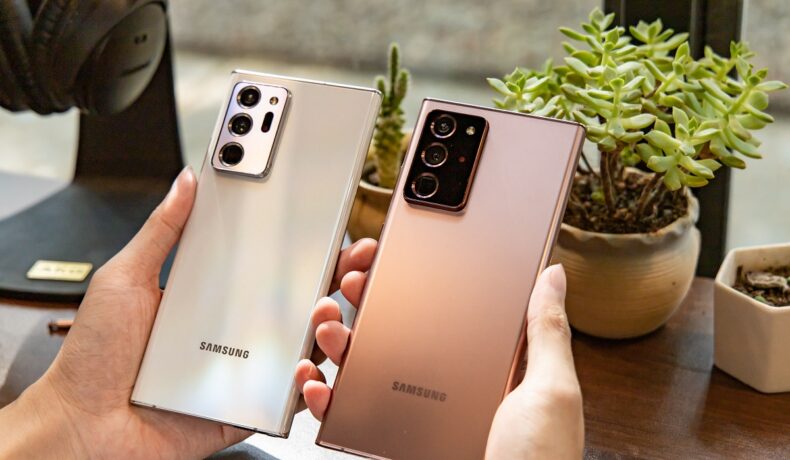 Telefoane Samsung Note 20 Ultra, ținute în mână de un utilizator, pe roz și argintiu. Samsung a lansat recent Galaxy A53