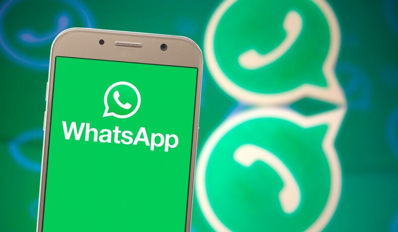 Telefon pe ecranul căruia se află WhatsApp, pe un fundal cu logoul WhatsApp, pe verde. WhatsApp ar putea crește limita de transfer de 20 de ori