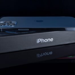 iPhone 12 Pro Max, de culoare albastră, pe o cutie gri și un fundal negru. iPhone 14 Pro ar putea avea un design diferit