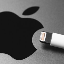 Simbol Apple, pe fundal gri, cu un căpat al încărcătorului. Apple a dezvăluit recent accident o actalizare importanta