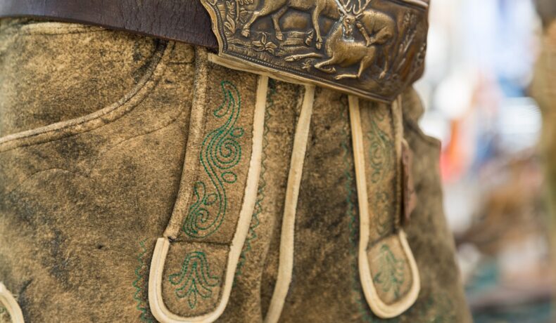 Pereche de pantaloni tradițională din Austria, din piele, cu o curea de bronz cu cerbi. Are o culoare similară cu cea mai veche pereche de pantaloni din lume