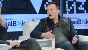 Elon Musk, în cadrul conferinței New York Times 2013 DealBook, New York, 2013. Stă pe un fotoliu alb, cu un fundal albastru. Elon Musk a dezvăluit recent de ce nu vrea să trăiască mai mult