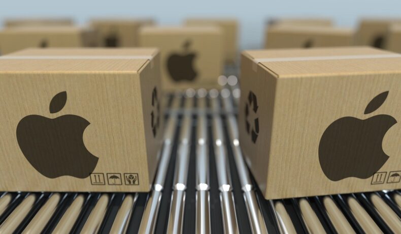 Cutii bej cu logo-ul Apple, pe o bandă rulantă. Dispozitivele iPhone ar putea fi mai dificil de găsit în viitorul apropiat