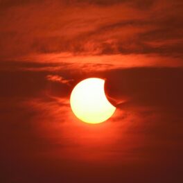 Eclipsă parțială de Soare, precum eclipsa solară de pe 30 aprilie 2022, pe fundal roșu