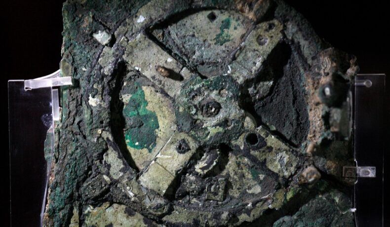 Mecanismul de la Antikythera, primul computer din lume, ce ar fi fost pornit pe 22 decembrie, pe fundal negru
