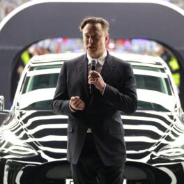 Elon Musk, la deschiderea gigafactoriei Tesla, ce a pierdut 126 de miliade de dolari din valoarea de piață, în fața unei mașini negre