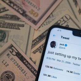 Telefon cu primul mesaj Twitter al lui Jack Dorsey, pe un teanc de bani. Un bărbat a cumpărat primul mesaj Twitter al lui Jack Dorsey