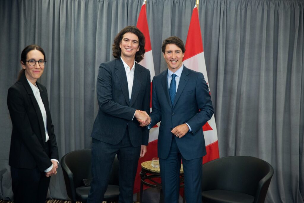 Adam Neumann și Justin Trudeau, 2018, amândoi în costum, dând mâna