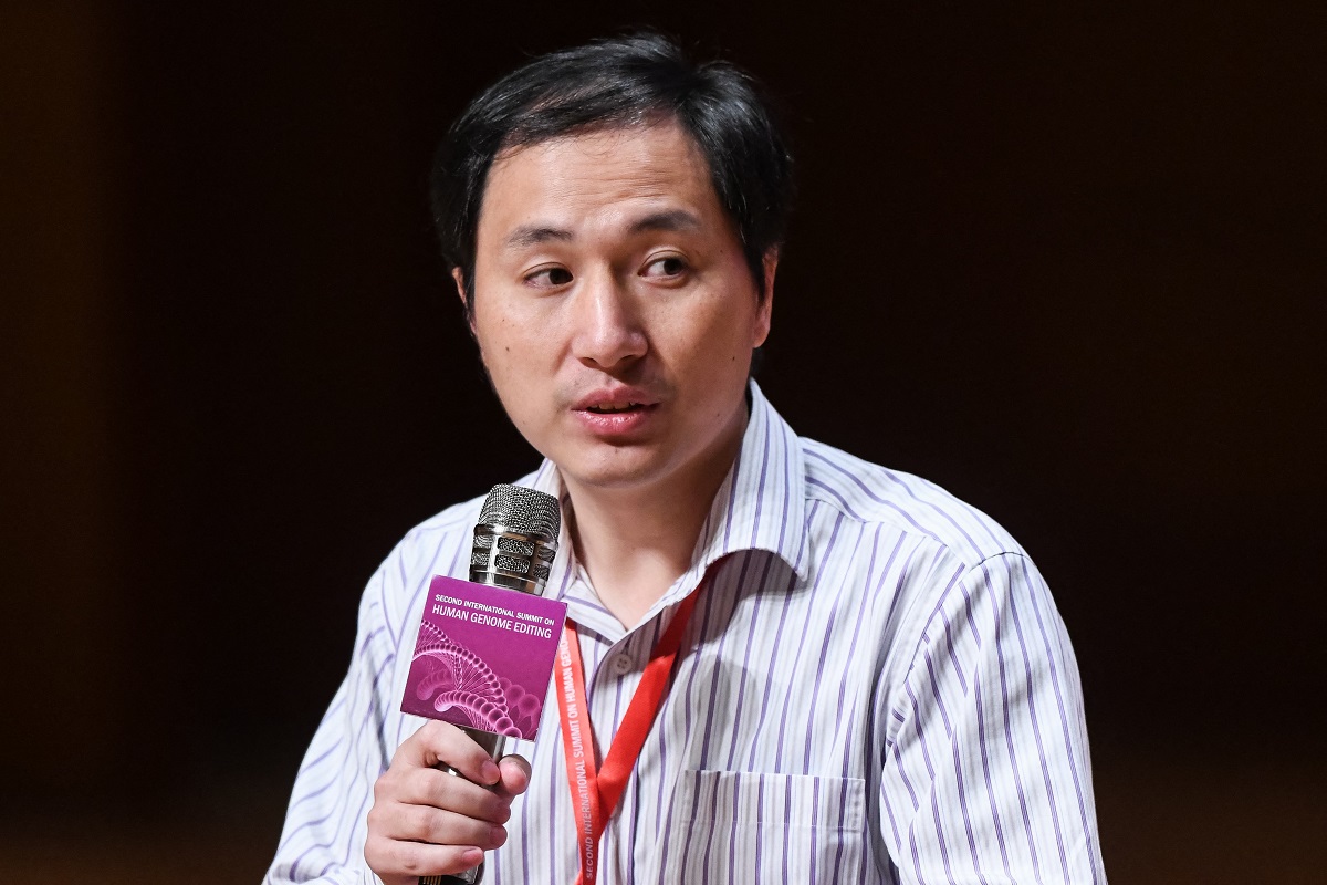 He Jiankui, la conferința Second International Summit on Human Genome Editing, 2018, vorbind la microfon, fundal negru