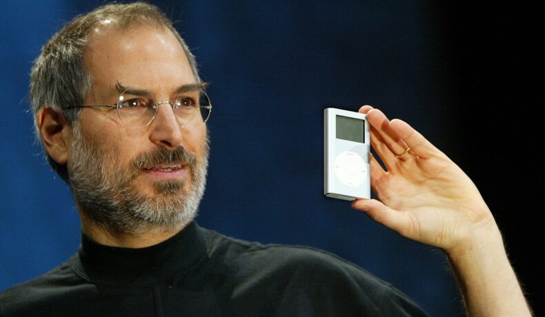 Steve Jobs, care ține în mână un iPod, pe scenă la un eveniment Apple. Apple a anunțat că oprește producția iPod