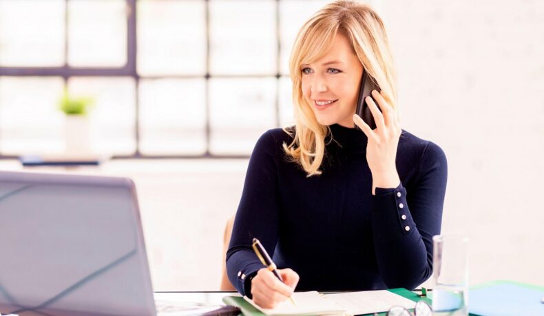 Persoană blondă care lucrează la un birou, cu laptop în față. Experții au studiat ce efect are munca de acasă asupra angajaților