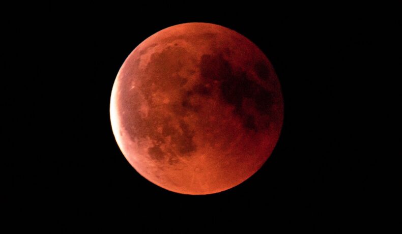 Eclipsă de Lună, de culoare sângerie, pe fundal negru, similară cu cea din mai 2022