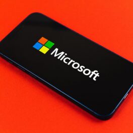 Telefon negru care are Microsoft pe ecran, pe fundal roșu. Recent, Microsoft, Amazon și Tesla au promis că vor acoperi costurile de transport pentru avort