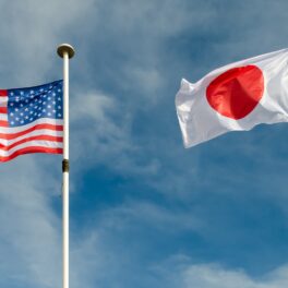 Steagurile SUA și Japonia, care vor colabora în programul Artemis, pe fundal albastru, cer
