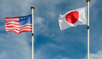 Steagurile SUA și Japonia, care vor colabora în programul Artemis, pe fundal albastru, cer
