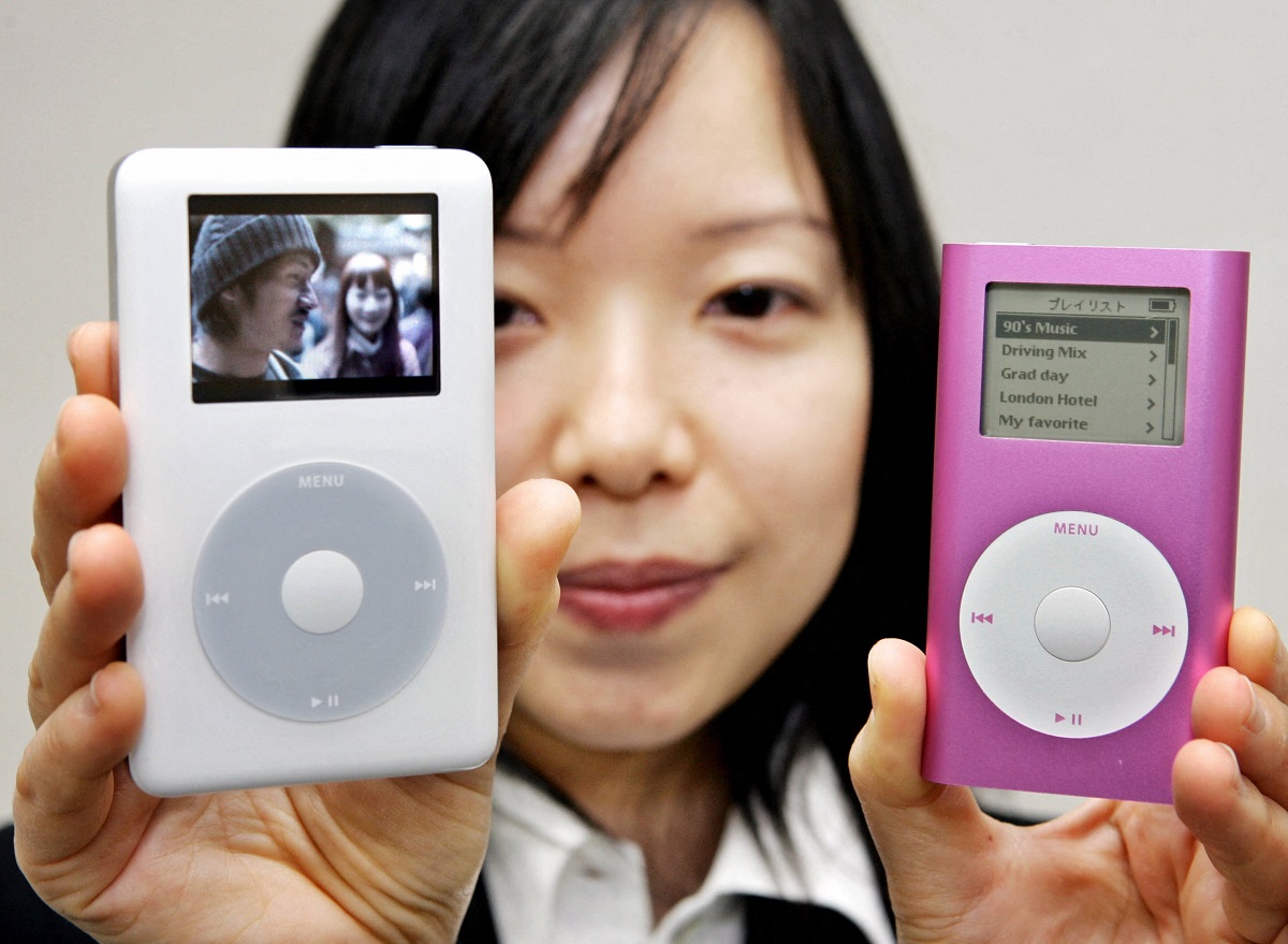 Utilizatoarea care are 2 dispozitive iPod în mâini, unul dintre ele alb, celălalt roz