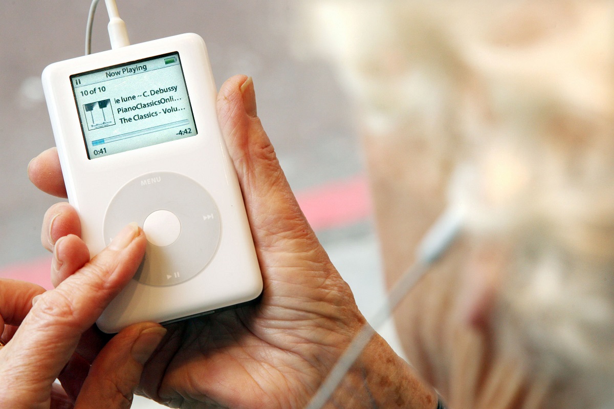 Utilizatoare în vârstă care ține în mână un iPod alb