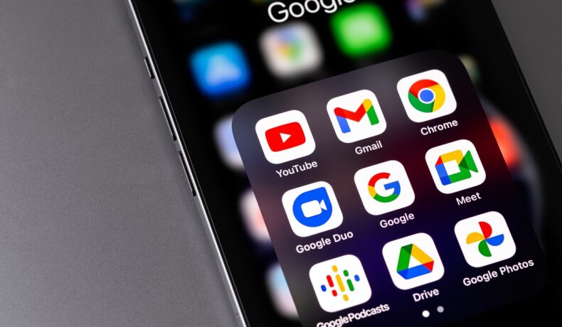 Telefon negru, pe fundal gri, cu numeroase aplicații Google, precum Google Talk, care va fi retras după 16 ani
