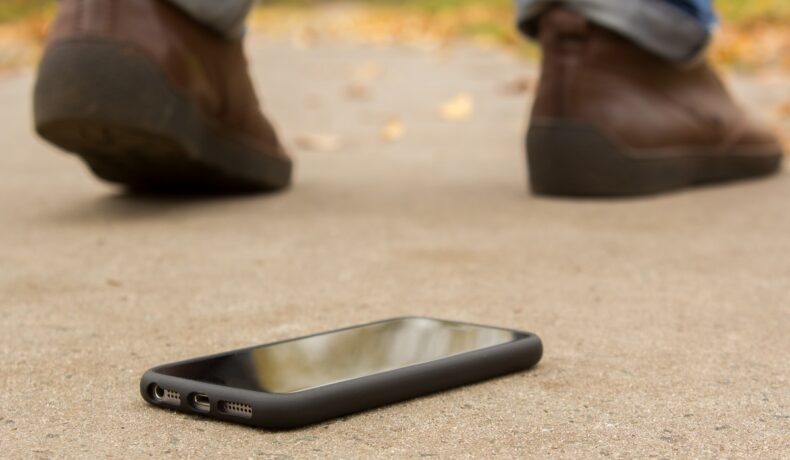 Utilizator care pleacă de lângă un telefon negru, care e pe jos. CEO-ul Nokia crede că utilizatorii vor renunța la smartphone-uri până în 2030
