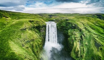 Cascadă spectaculoasă în Islanda, cea mai sigură țară din lume, înconjurată de verde.