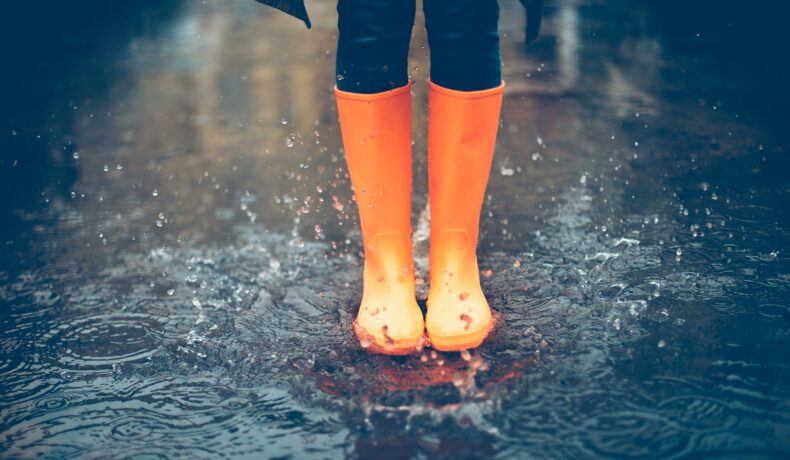 Persoană care poartă cizme galbene, în ploaie. Potrivit experților, apa de ploaie nu e potabilă nicăieri pe Pământ