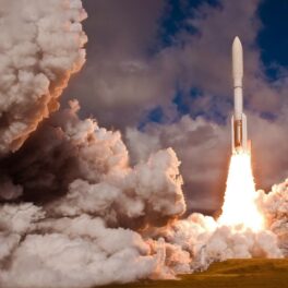 Rachetă lansată în spațiu, cu nori pe fundal, ca cea care va duce un microsatelit construit de liceeni români în spațiu