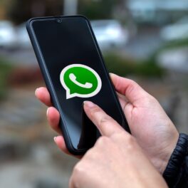 Utilizator care are în mână telefon mobil, cu WhatsApp pe ecran, ce nu va mai funcționa pe unele dispozitive