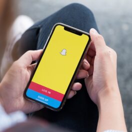 O femeie care ține în mână un tlefon deschis în aplicația de Snapchat