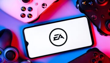 Telefon mobil cu logo-ul Electronic Arts pe ecran, pe fundal cu controllers de console, lumină mov. Electronic Arts va închide serverele pentru mai multe jocuri
