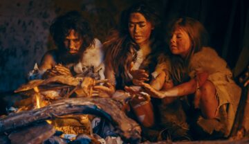 Familie de oameni de Neanderthal, similară cu prima, care stă în fața unui foc și se încălzește
