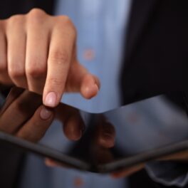 Persoană care ține un telefon pliabil în mâini, similar cu Huawei Pocket S, care e cel mai ieftin telefon pliabil lansat până acum