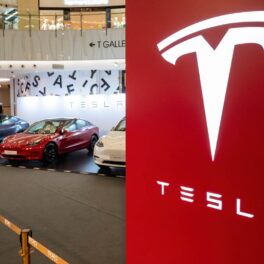 Logo Tesla, pe roșu, cu mașini pe fundal. Recent, au fost făcute publice imagini inedite din apropierea fabricii lui Elon Musk