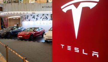 Logo Tesla, pe roșu, cu mașini pe fundal. Recent, au fost făcute publice imagini inedite din apropierea fabricii lui Elon Musk