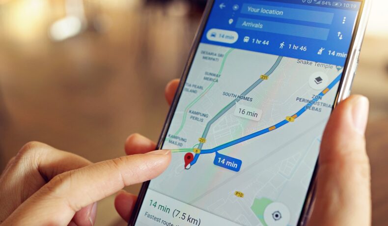 Utilizator care ține în mână un telefon cu Google Maps pe ecran. HERE e aplicația care a întrecut Google Maps