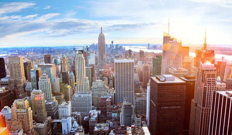 Imagine cu clădirile din New York, cer senin, care se numără printre cele mai bogate orașe din lume