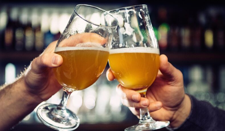 Două persoane care ciocnesc pahare cu bere. OMS a dezvăluit în ce țară din Europa se consumă cel mai mult alcool