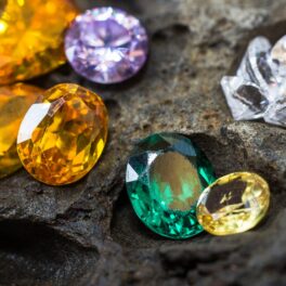 Imagine cu mai multe pietre prețioase, pe o rocă, similare cu Kyawthuite, cel mai rar mineral de pe Pământ