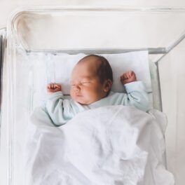 Copil nou-născut care doarme în pat, cu cearșaf alb. Un caz medical extrem de rar a atras atenția doctorilor