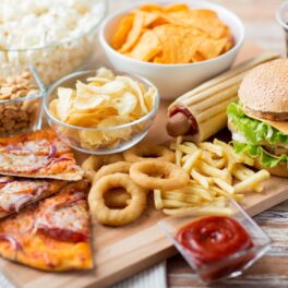 Mâncare fast food, pizza, burger, cartofi prăjiți, chipsuri, pe un blat, printre dulciurile și alimentele grase care pot schimba creierul uman