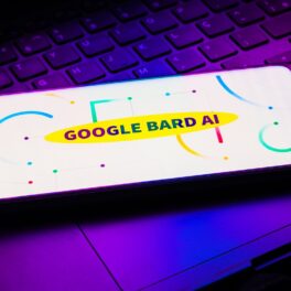Google Bard, care poate fi accesat acum de către public, pe ecranul unui smartphone care stă pe tastatură