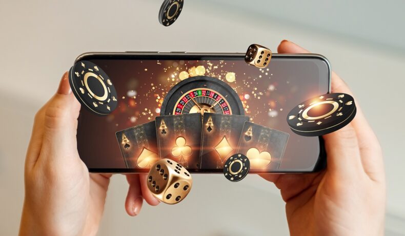 Telefon ținut în mână, cu jocuri de noroc pe ecran, pe fundal alb, pentru a ilustra medicamentul care ar crește riscul dependenței de jocuri de noroc