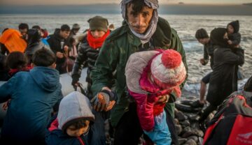 Bărbat imigrant care ține de mână 2 copii în timp ce se dă jos de pe o barcă, la fel ca un pescar care risca o sentință de mii de ani