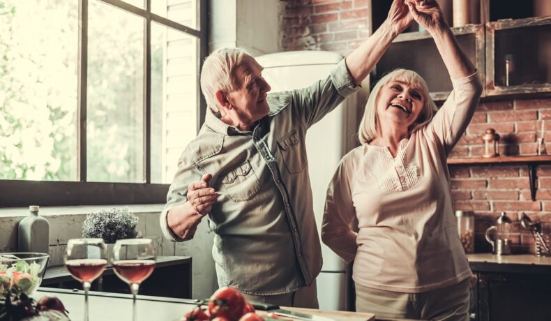 Doi bătrâni care dansează în bucătărie, pentru a ilustra secretul longevității, care e știut deja