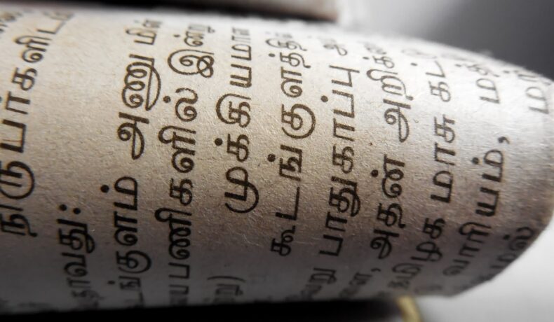 Foaie albă care are limba tamilă scrisă pe ea cu negru, cea mai veche limbă din lume