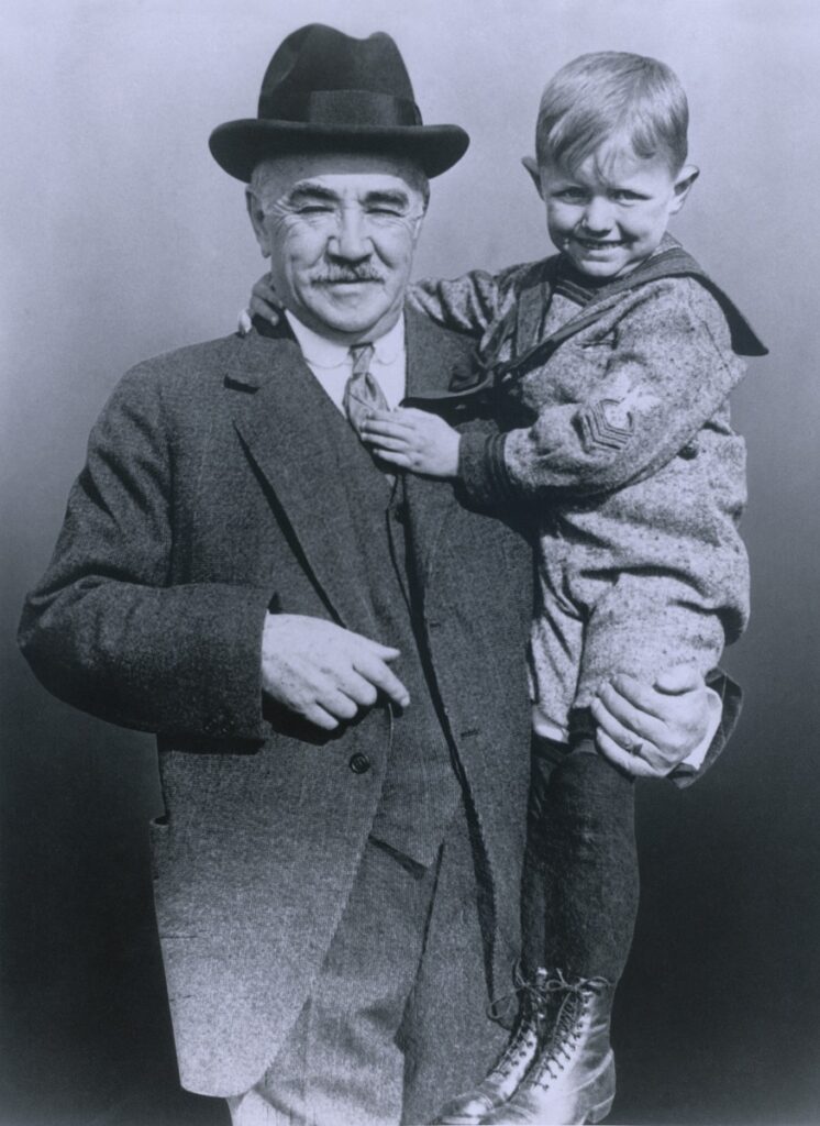 Milton Hershey care ținea în brațe un copil, fotografie alb-negru, s-a numărat printre acele persoane faimoase care aveau bilete pentru Titanic