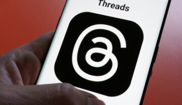 Utilizator care are un telefon în mână cu aplicația Threads pe ecran, pentru a ilustra că Threads nu funcționează în Europa