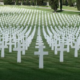 Memorial american din Italia, cu multe cruci albe pe un teren cu iarbă, pentru a ilustra ziua în care au murit 100.000 de oameni